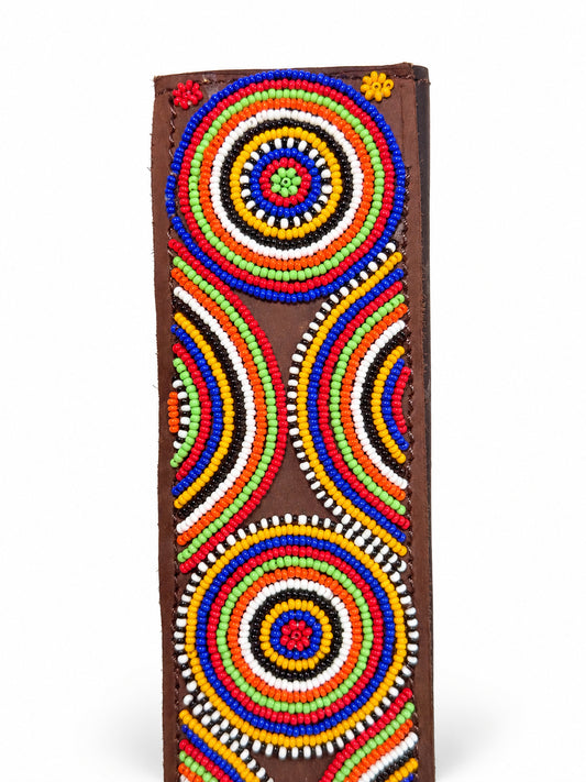 Close-up of hand-stitched rainbow bead circles on a brown leather seat belt cover