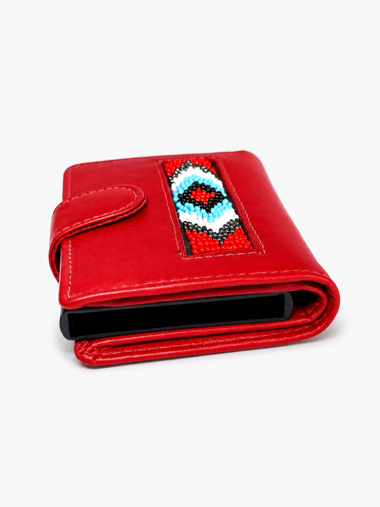 Close‑up of artisan beadwork design on red leather wallet

