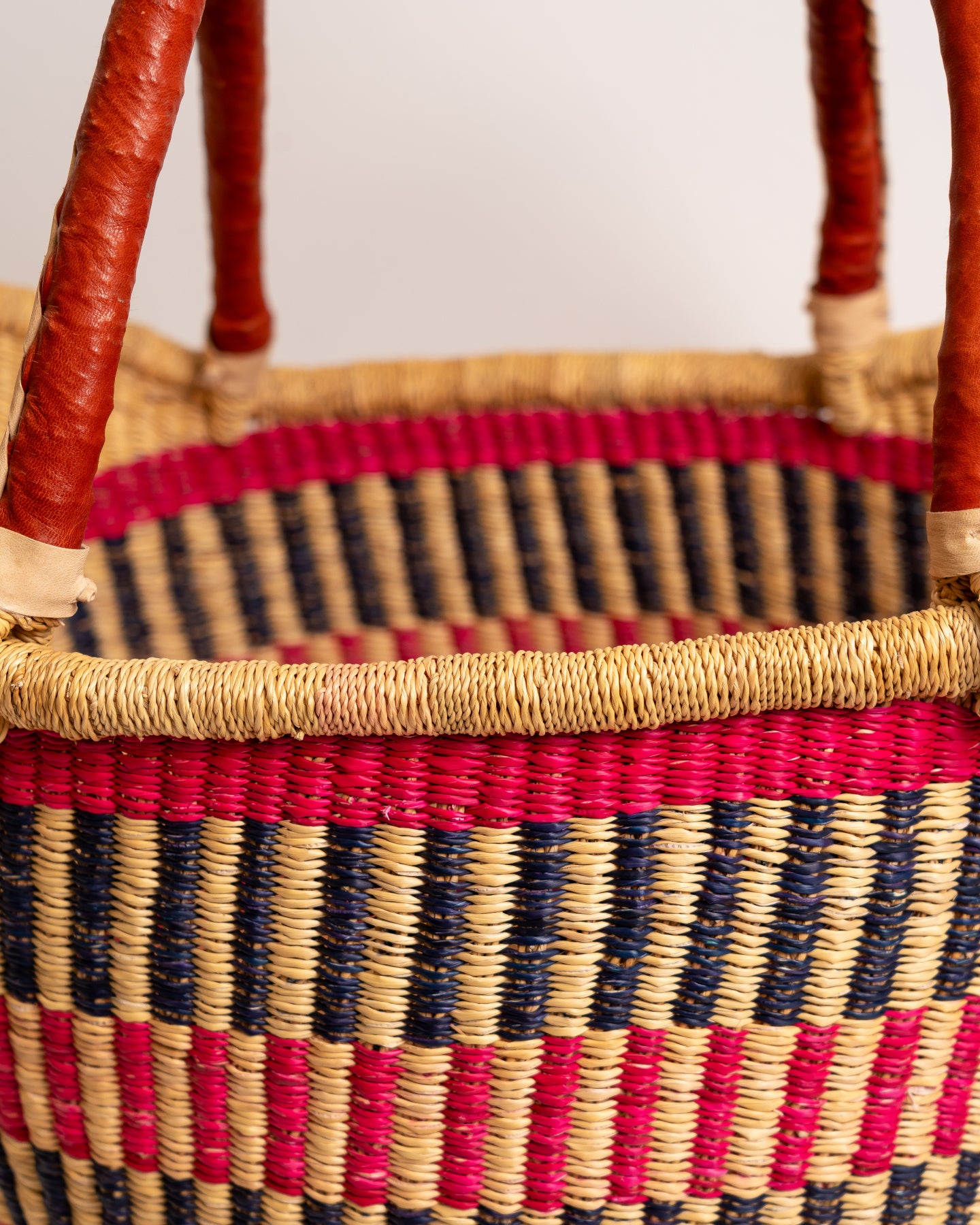 Woven basket with red and black pattern on a plain background