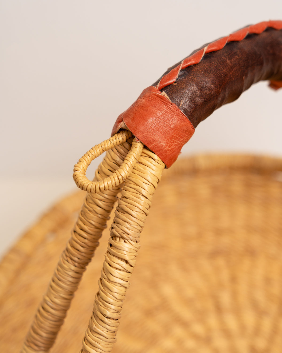 Leather-wrapped handle detail on a Bolga tray basket