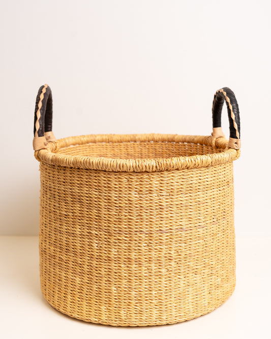 Handwoven natural Bolga storage basket with braided black leather handles, made from elephant grass by Ghanaian artisans — Nathez Out of Africa