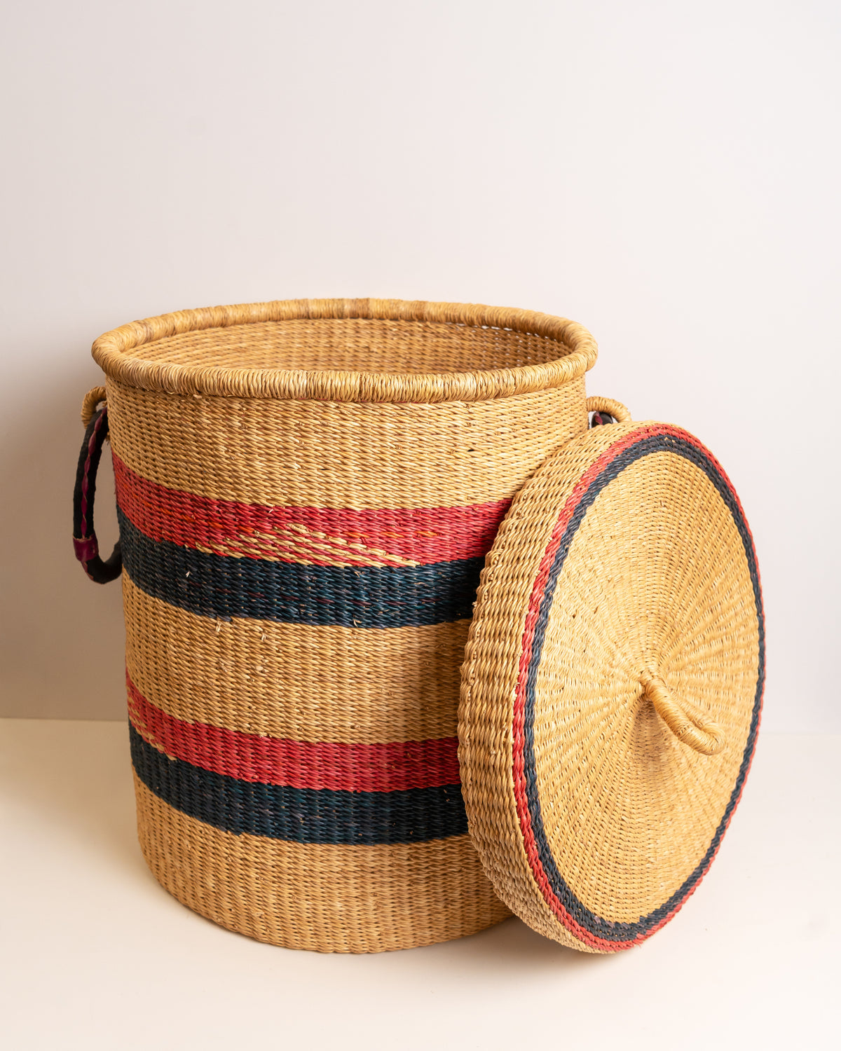 Handwoven Bolga laundry basket with lid in red and navy stripe - elephant grass storage hamper handmade in Ghana