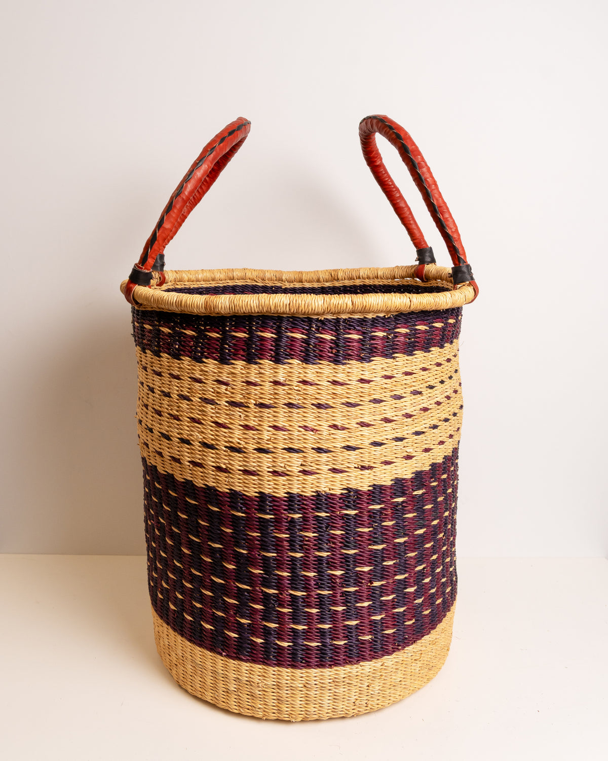 X-Large handwoven Bolga laundry basket in burgundy and tan stripe with leather handles up - full view, elephant grass storage hamper, Ghana