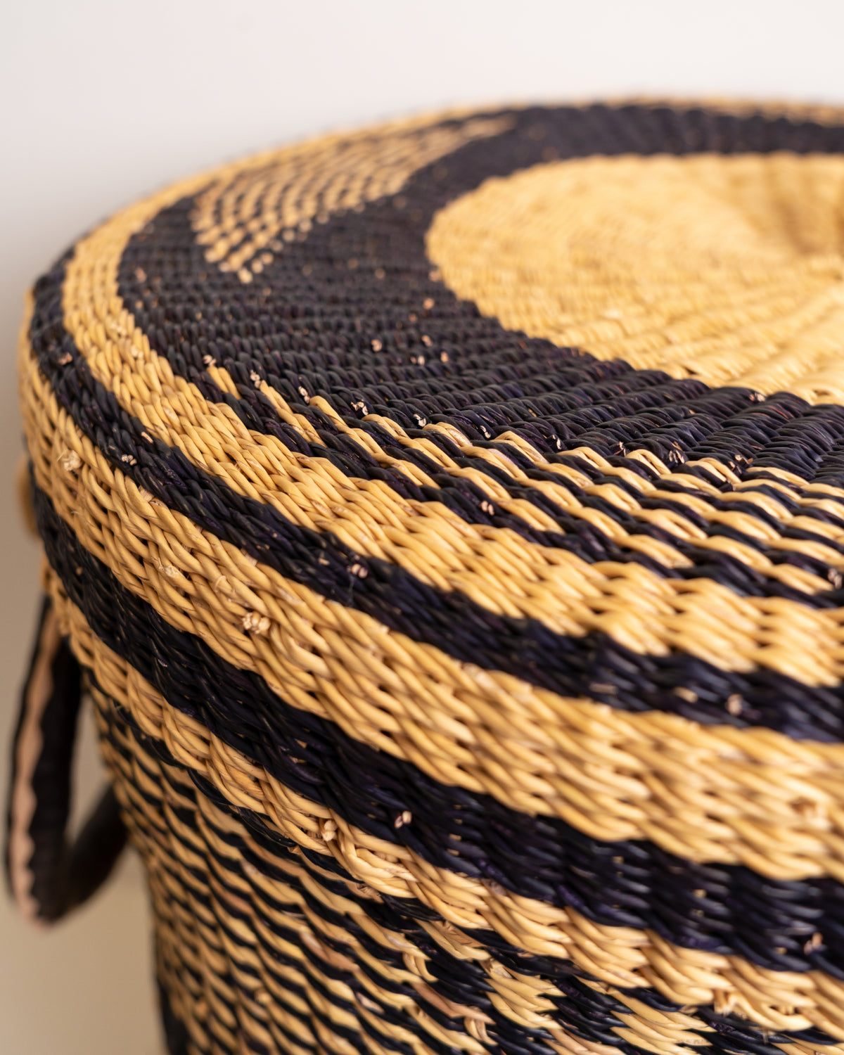 Bolga laundry basket lid close-up, handwoven elephant grass spiral pattern, Ghana