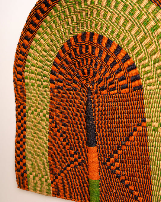 Close-up of a large handwoven Bolga wall fan in orange, lime green and black elephant grass, Ghana