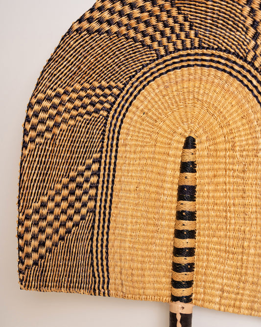 Close-up of the natural and black checkerboard weave and striped centre on a large handwoven Bolga wall fan