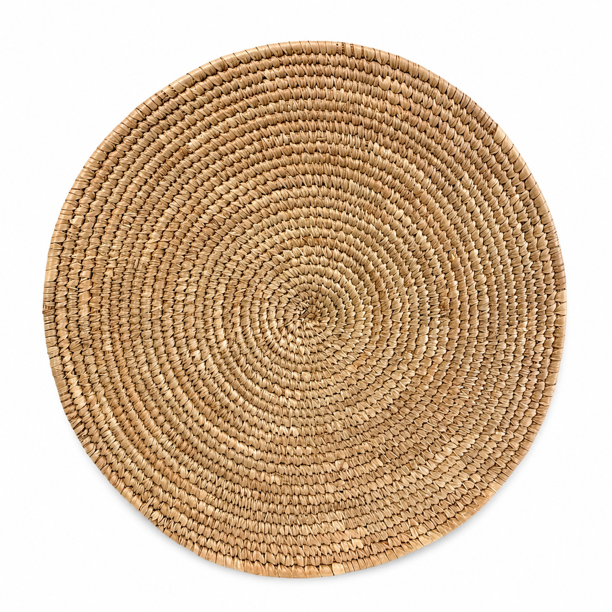 Handwoven natural seagrass round placemat on a white background featuring a circular woven design in natural beige tones.