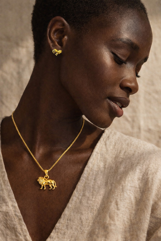 Woman wearing an 18k gold-plated lion pendant necklace and matching lion stud earring from the Big 5 lion necklace and earring set by H2Wild