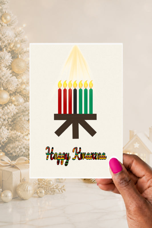 Hand holding a Happy Kwanzaa greeting card featuring a kinara with seven red, black and green candles.