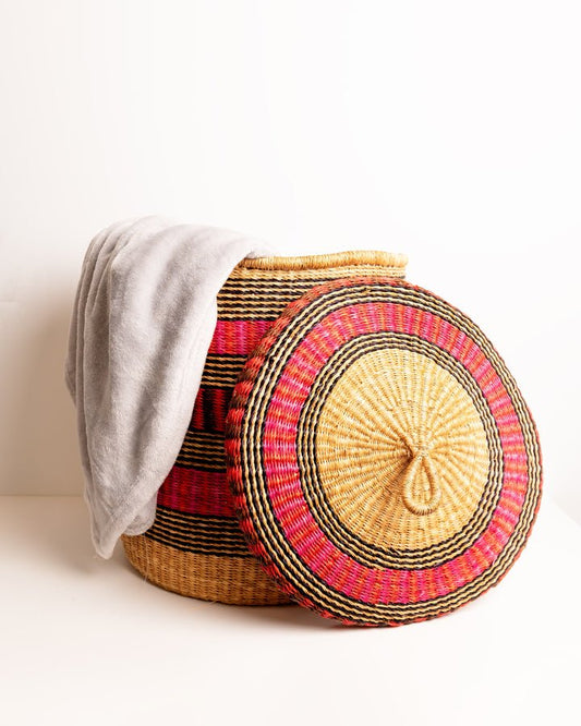 Close-up of the round woven lid on a Bolga laundry basket with lid, pink and red stripe elephant grass weave, handmade in Ghana