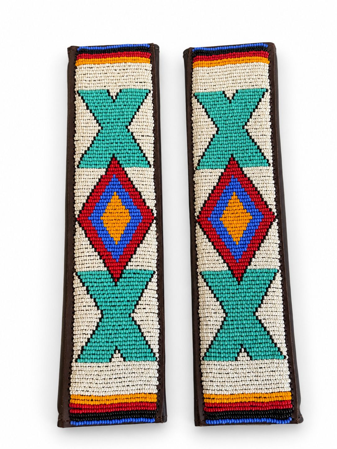 Two cream and turquoise beaded seat belt covers at an angle, handmade in Kenya