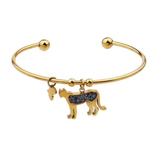 Gold-plated open cuff cheetah bangle with a cheetah charm set with snowflake obsidian stone chips and a small Africa-shaped charm, on a plain white background.
