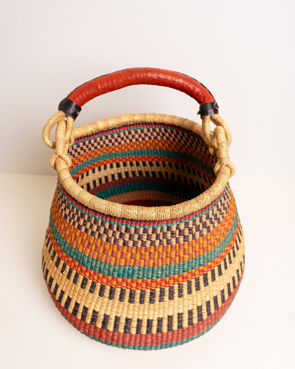 Angled view of the teal and terracotta Ahoufe storage basket, showing its rounded pot shape and patterned interior.